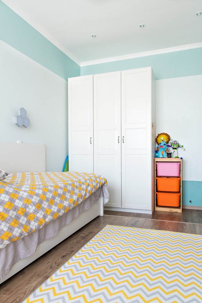 Idee per una cameretta per bambini da 4 a 10 anni design di medie dimensioni con pareti blu, pavimento in laminato e pavimento marrone