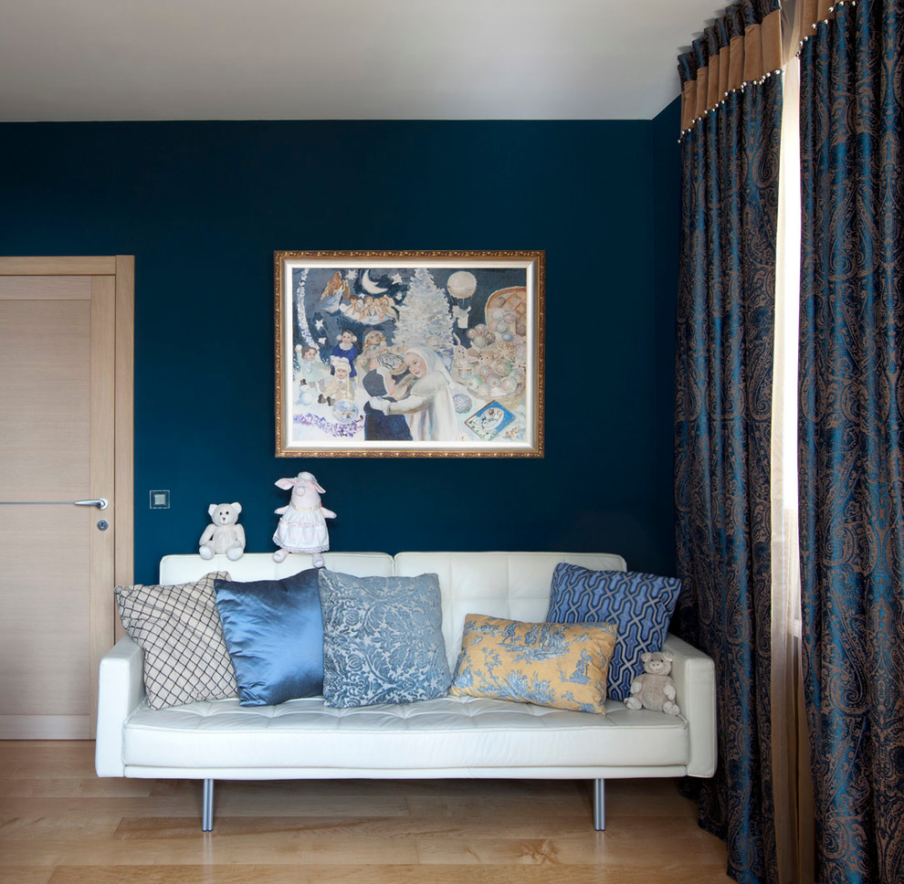 Ejemplo de dormitorio infantil de 1 a 3 años contemporáneo de tamaño medio con paredes azules y suelo de madera en tonos medios