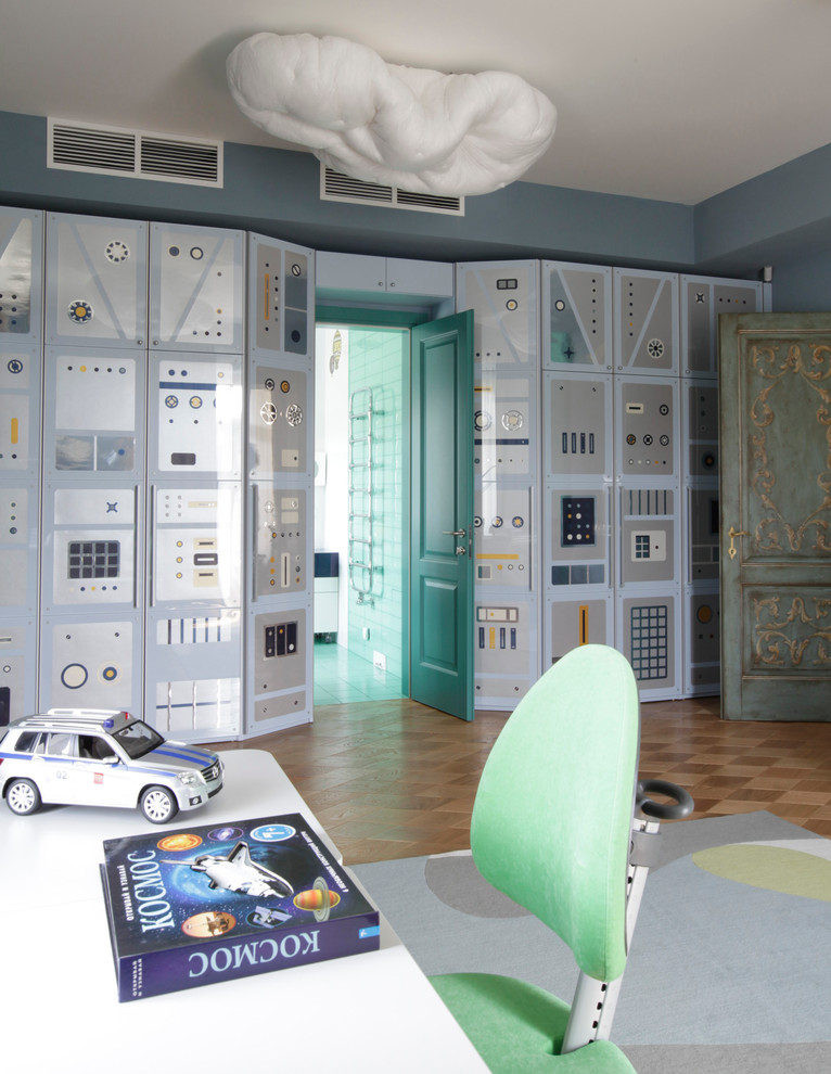 Modelo de habitación de niño contemporánea grande con paredes azules, suelo de madera en tonos medios y escritorio