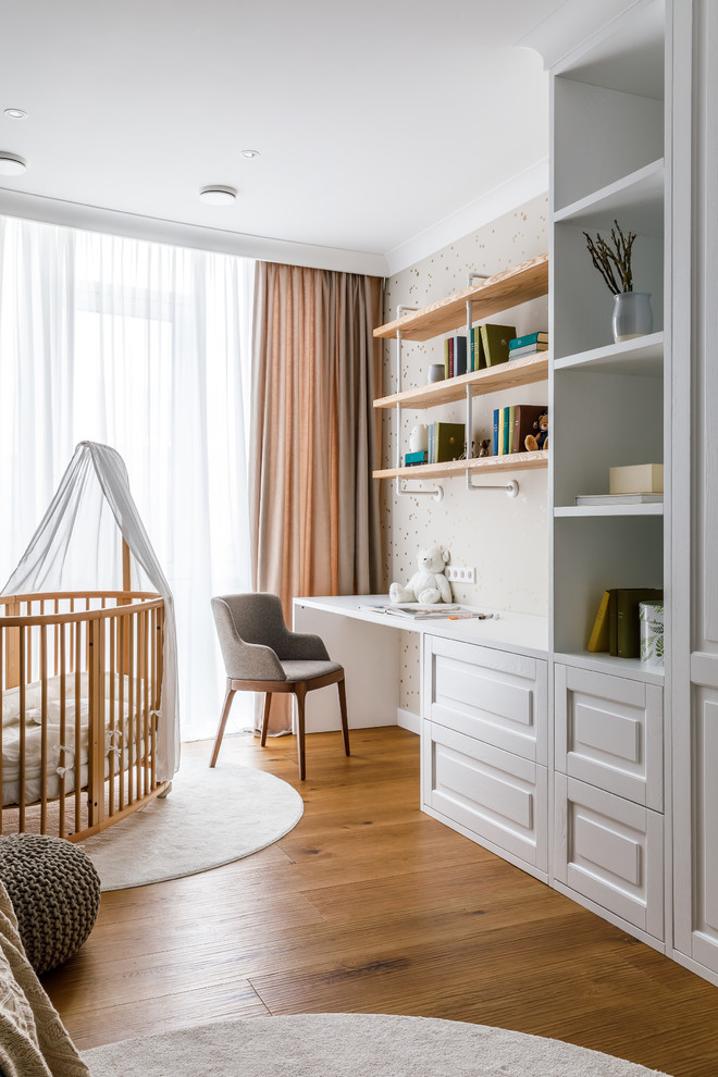 На фото: детская среднего размера в современном стиле с спальным местом, синими стенами, полом из ламината и коричневым полом для ребенка от 1 до 3 лет, мальчика с