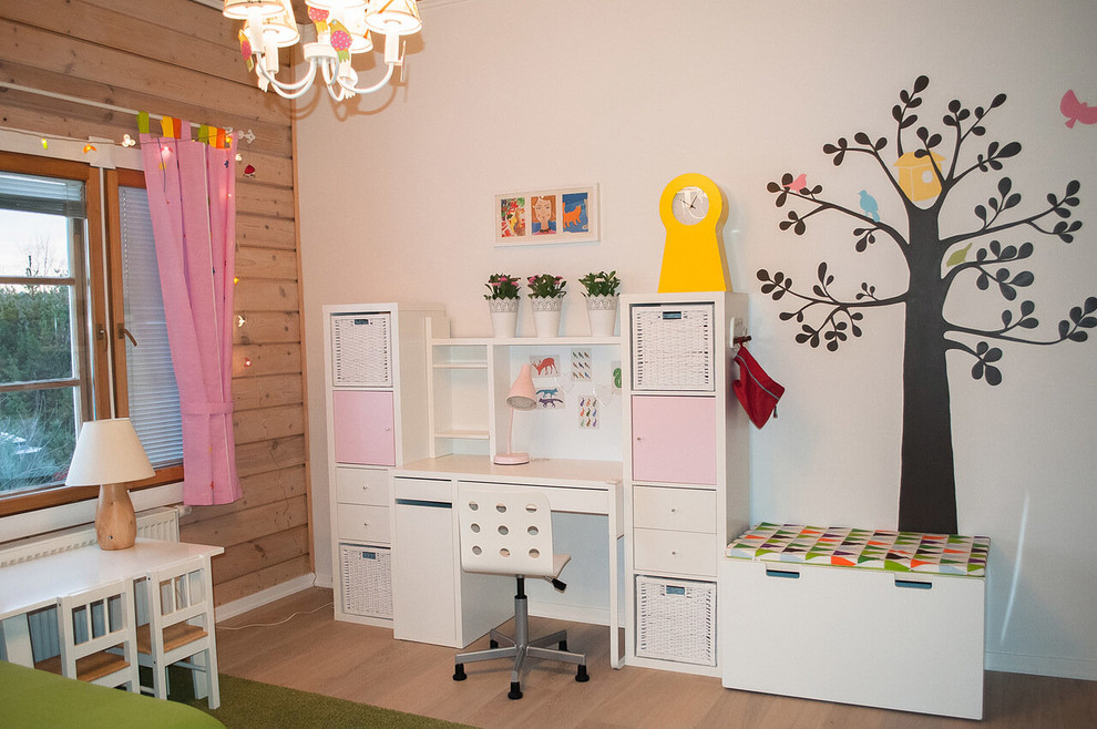 Esempio di una cameretta per bambini da 4 a 10 anni scandinava di medie dimensioni con pareti beige, pavimento in legno massello medio e pavimento beige