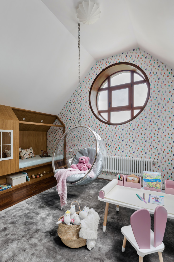 Aménagement d'une chambre d'enfant de 1 à 3 ans contemporaine avec un mur multicolore, un sol en bois brun et du papier peint.