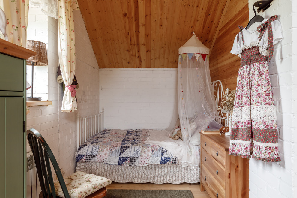 Design ideas for a country children’s room for girls in Other with white walls and light hardwood flooring.
