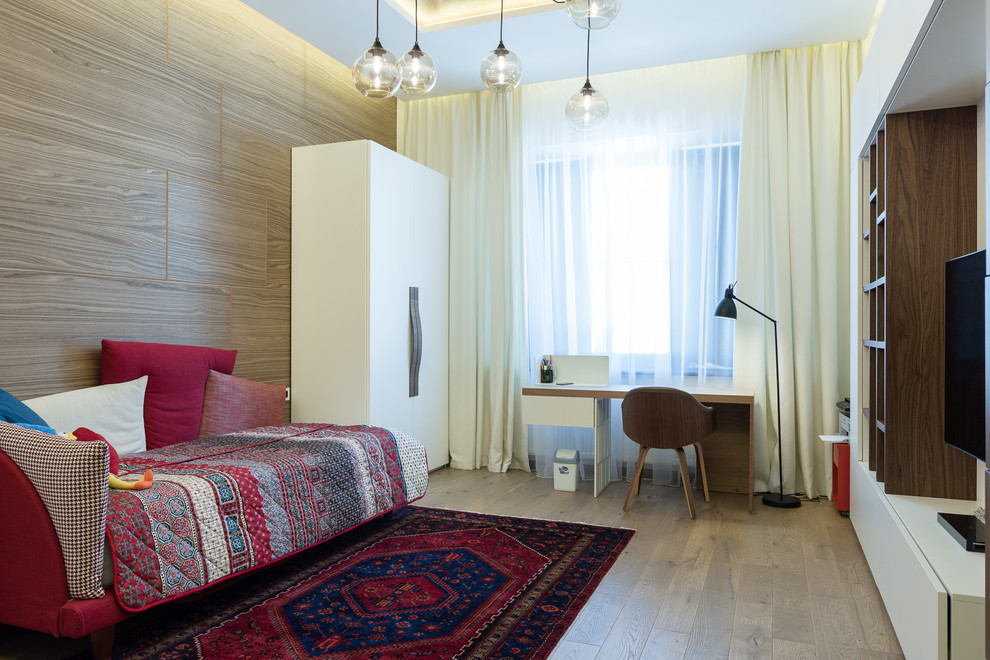 Foto på ett mellanstort skandinaviskt barnrum kombinerat med sovrum, med vita väggar, mellanmörkt trägolv och brunt golv