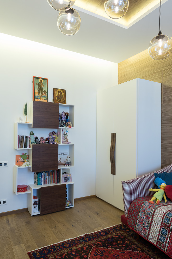 Bild på ett mellanstort minimalistiskt barnrum kombinerat med sovrum, med vita väggar, mellanmörkt trägolv och brunt golv