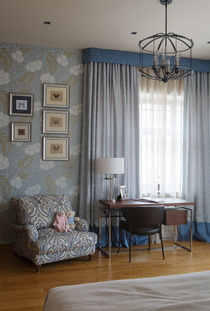 Idée de décoration pour une chambre de fille design avec un bureau, un mur bleu et un sol en bois brun.