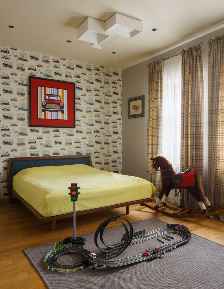 На фото: детская в современном стиле с спальным местом, разноцветными стенами и паркетным полом среднего тона для ребенка от 4 до 10 лет, мальчика с