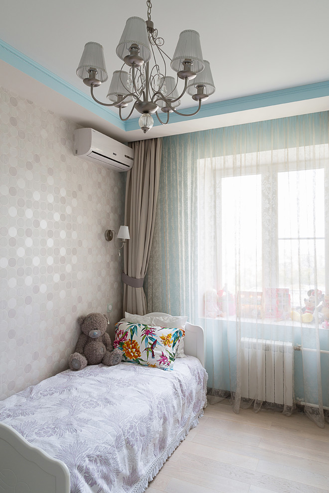 Imagen de dormitorio infantil de 4 a 10 años actual con paredes beige y suelo de madera clara