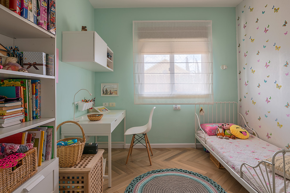 Ejemplo de habitación de niña de 4 a 10 años escandinava con paredes azules y suelo de madera clara