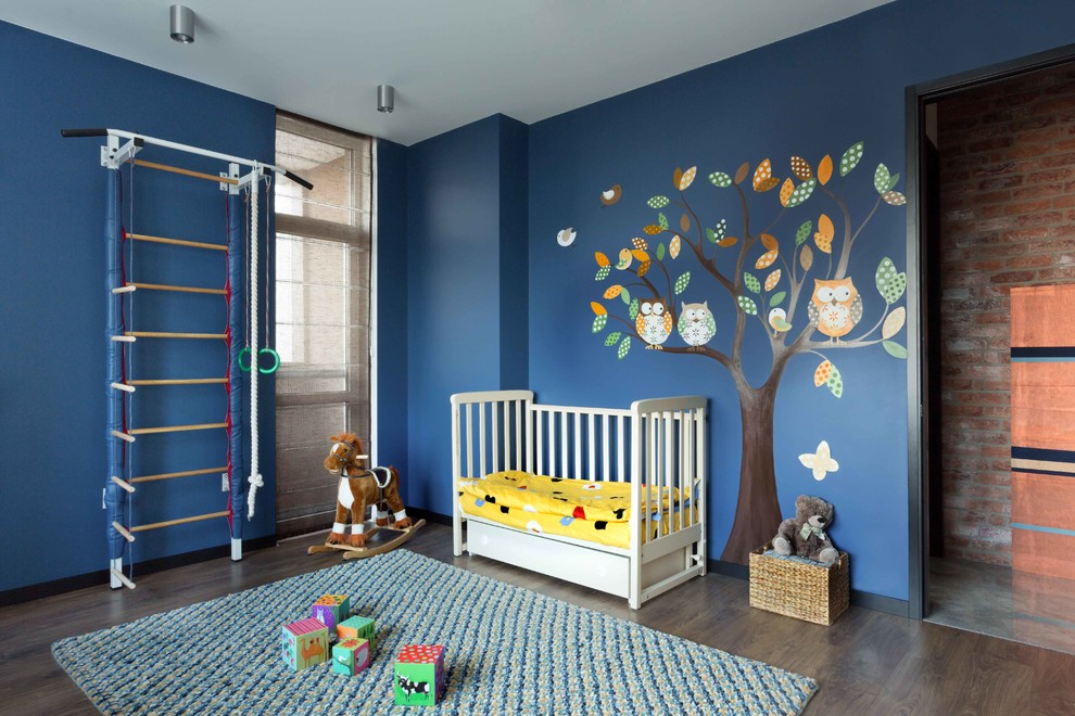 Klassisk inredning av ett könsneutralt småbarnsrum, med blå väggar och mörkt trägolv