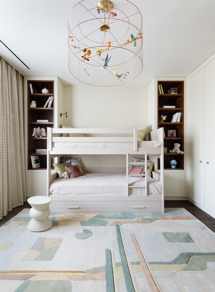 Traditional children’s room for girls in Moscow with dark hardwood flooring, white walls and feature lighting.