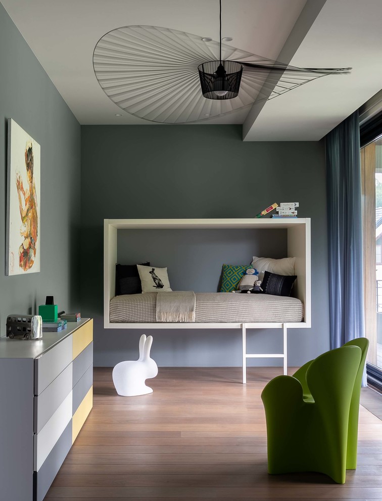 Inspiration för moderna könsneutrala barnrum kombinerat med sovrum, med grå väggar, mellanmörkt trägolv och brunt golv