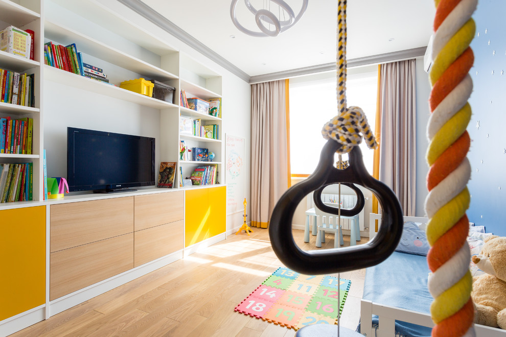 Ispirazione per una cameretta per bambini da 1 a 3 anni contemporanea di medie dimensioni con pareti blu, parquet chiaro e pavimento beige