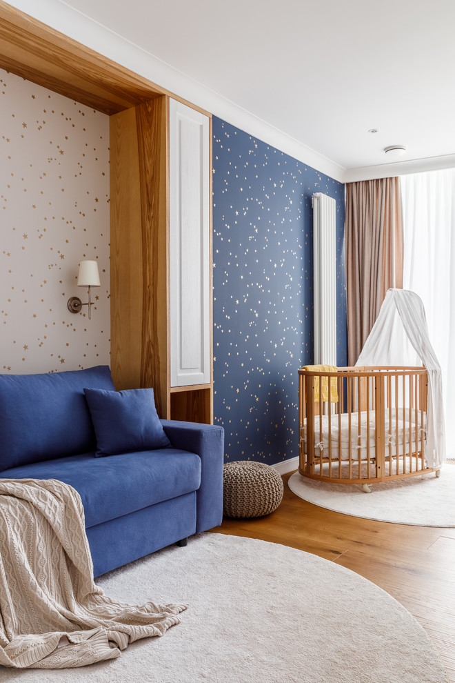 Exempel på ett mellanstort modernt barnrum kombinerat med sovrum, med blå väggar, laminatgolv och brunt golv