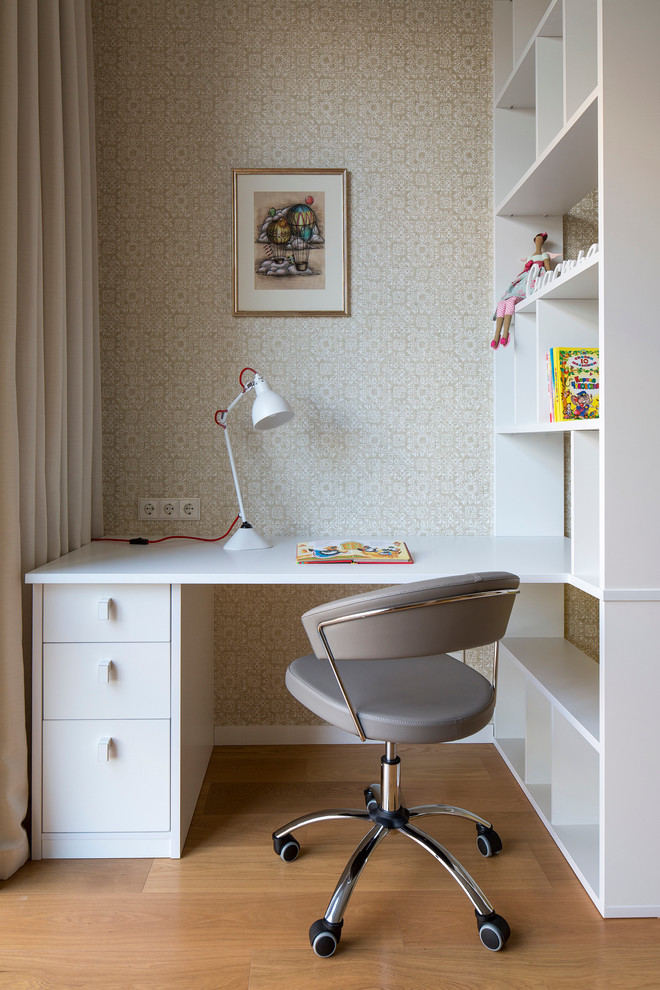 Idées déco pour une chambre de fille contemporaine avec un bureau, un mur beige et un sol en bois brun.
