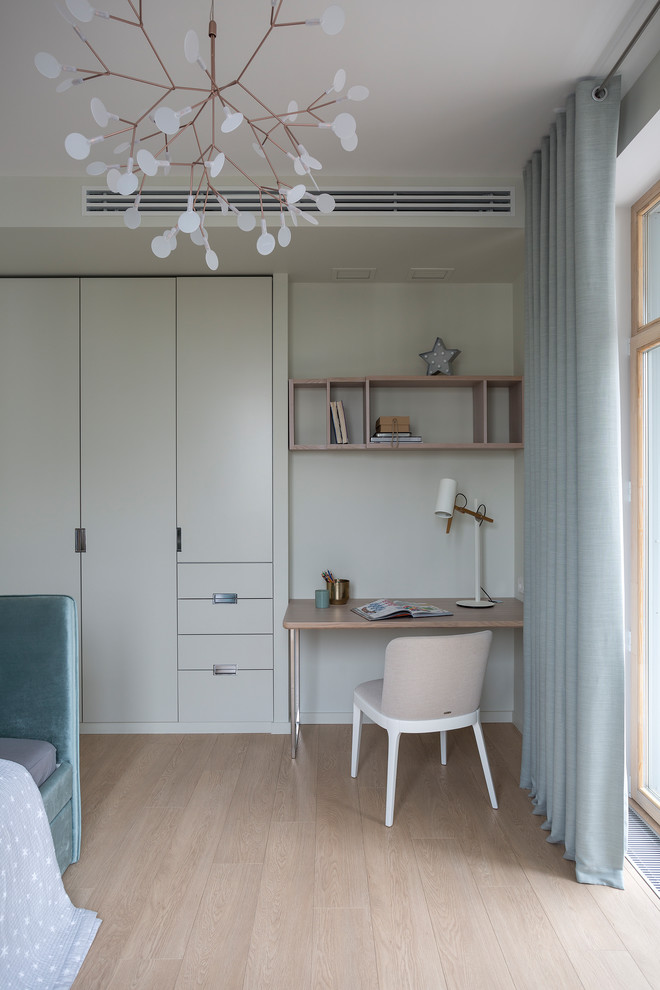 Réalisation d'une chambre neutre design avec un bureau, un mur blanc, parquet clair et un sol beige.