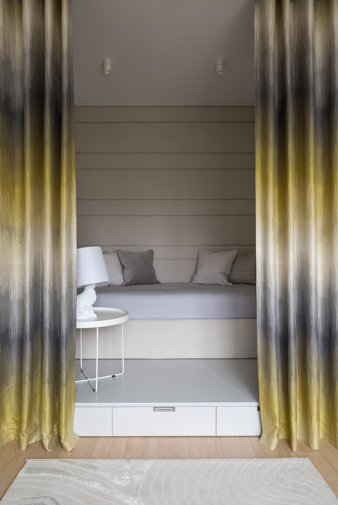 Diseño de dormitorio infantil contemporáneo con paredes beige, suelo de madera clara y suelo beige