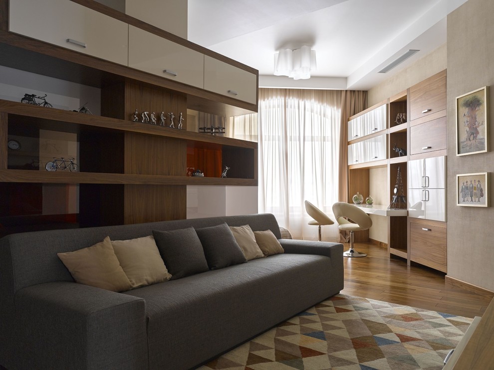 Aménagement d'une grande chambre neutre de 4 à 10 ans contemporaine avec un mur beige, un sol en bois brun, un bureau et un sol marron.