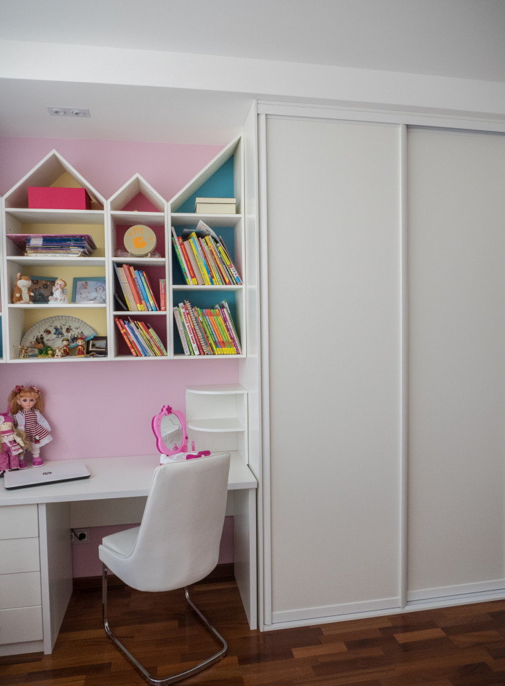Foto de habitación de niña de 4 a 10 años actual de tamaño medio con escritorio, paredes multicolor, suelo de madera en tonos medios y suelo marrón
