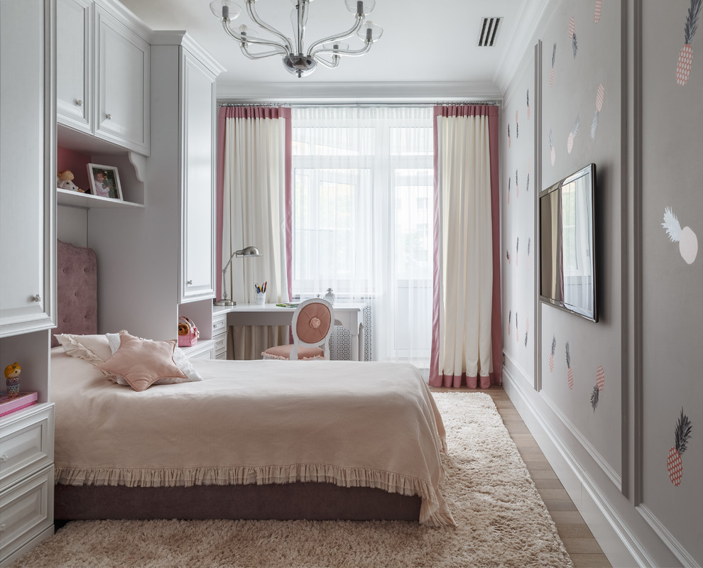 This is an example of a traditional kids' bedroom for girls in Other with white walls and light hardwood flooring.