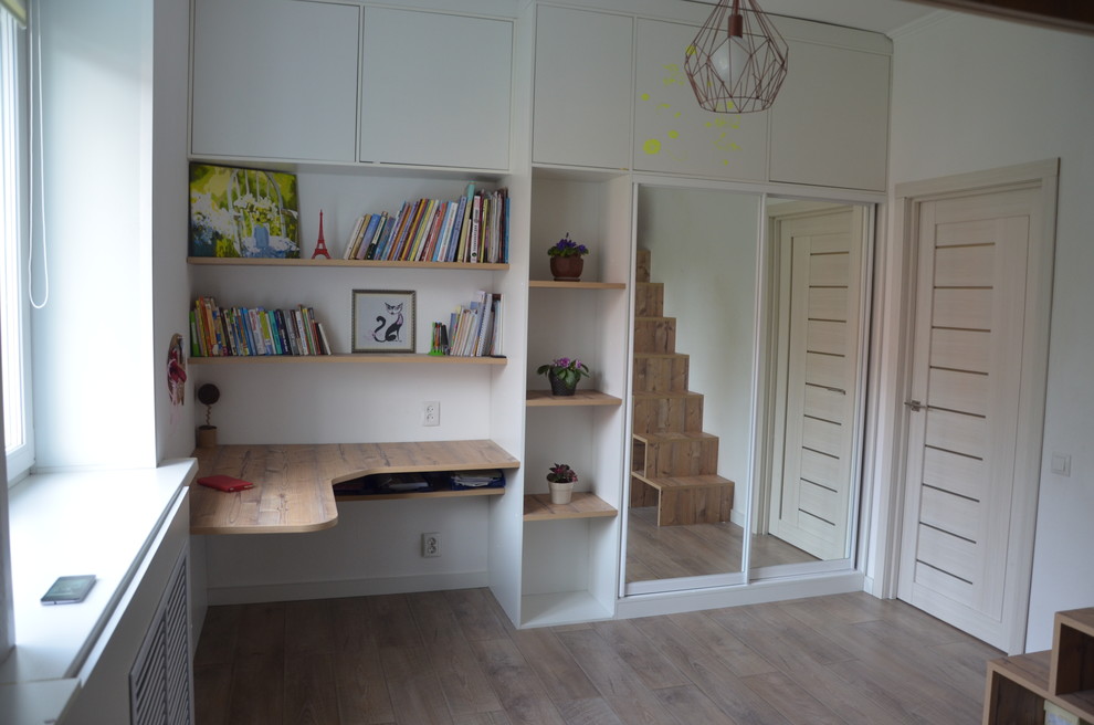 Ispirazione per una cameretta per bambini design con pareti bianche e pavimento in laminato