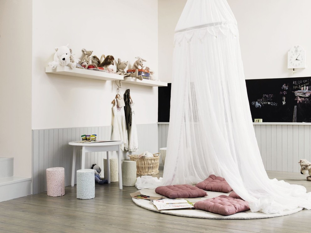 Foto på ett mellanstort skandinaviskt flickrum kombinerat med lekrum, med mellanmörkt trägolv och vita väggar