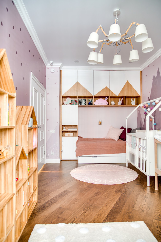 Ispirazione per una cameretta per bambini design con pareti viola, pavimento in legno massello medio e pavimento marrone