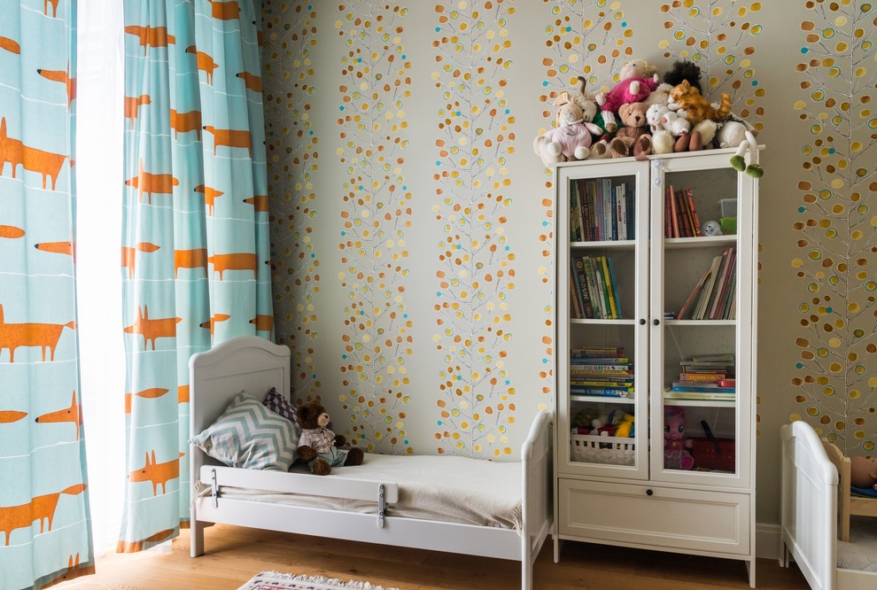 Aménagement d'une petite chambre d'enfant de 1 à 3 ans contemporaine avec un mur multicolore et un sol en bois brun.