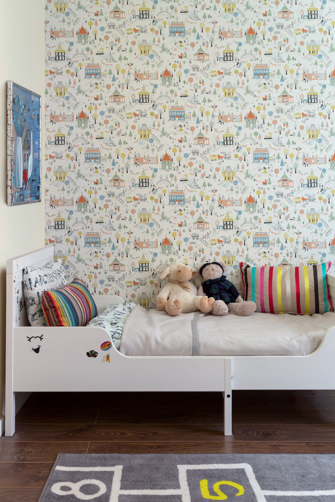 Immagine di una piccola cameretta da letto da 1 a 3 anni minimal con pavimento in laminato, pavimento marrone e pareti multicolore