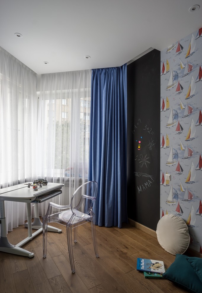 Idées déco pour une chambre de garçon contemporaine avec un bureau, un mur bleu et un sol en bois brun.