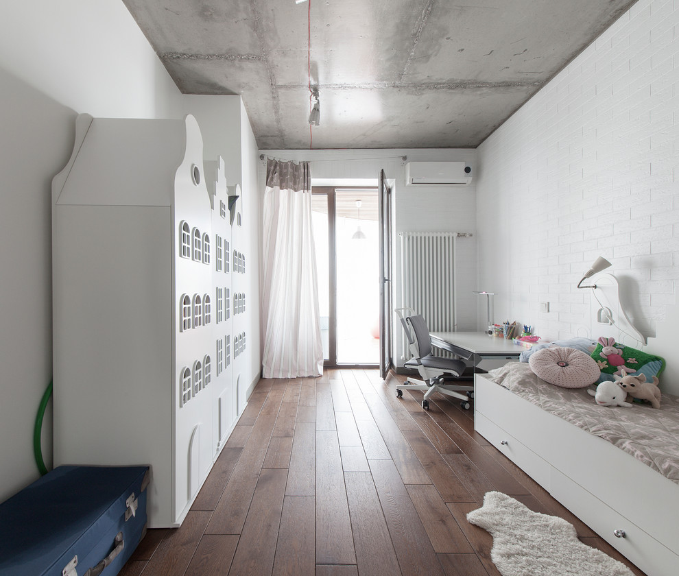 Cette image montre une petite chambre neutre de 4 à 10 ans urbaine avec un mur blanc et un sol en bois brun.