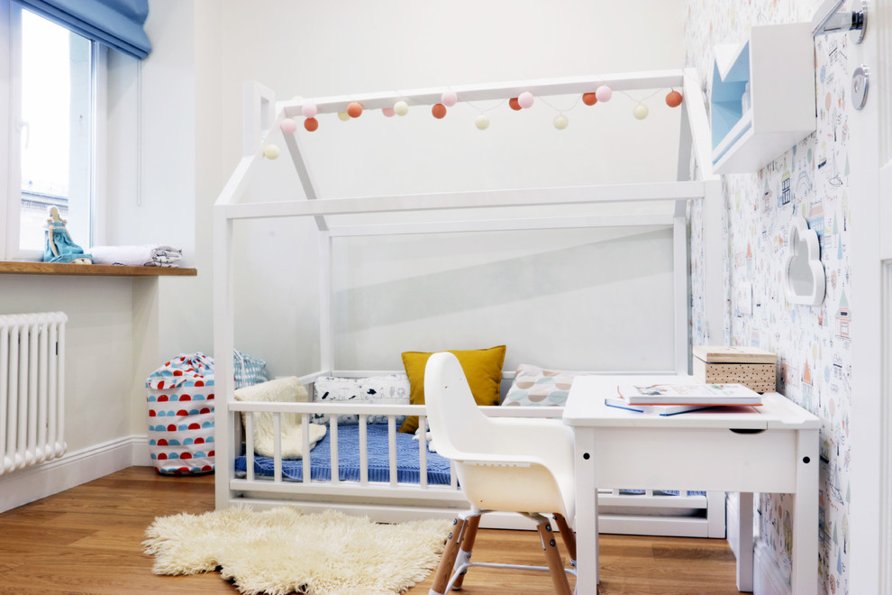 Photo of a small scandinavian kids' bedroom for girls in Moscow with white walls, medium hardwood flooring and brown floors.