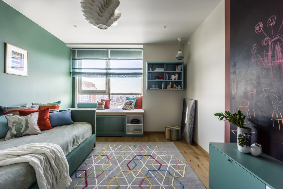 Idée de décoration pour une chambre d'enfant design avec un mur vert, un sol en bois brun et un sol marron.