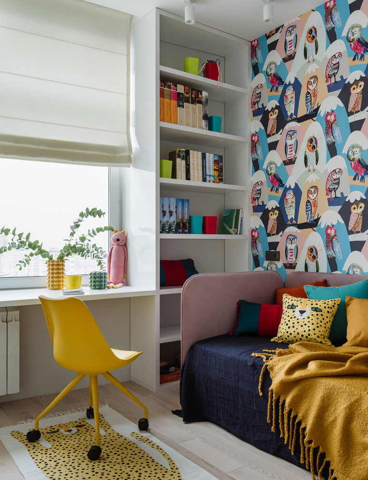 Photo of a contemporary children’s room for girls in Moscow with multi-coloured walls, light hardwood flooring and a feature wall.