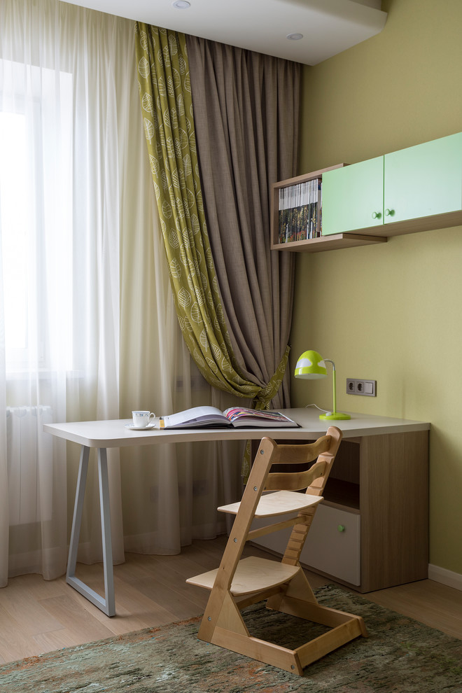 На фото: нейтральная детская в современном стиле с рабочим местом, зелеными стенами и светлым паркетным полом с