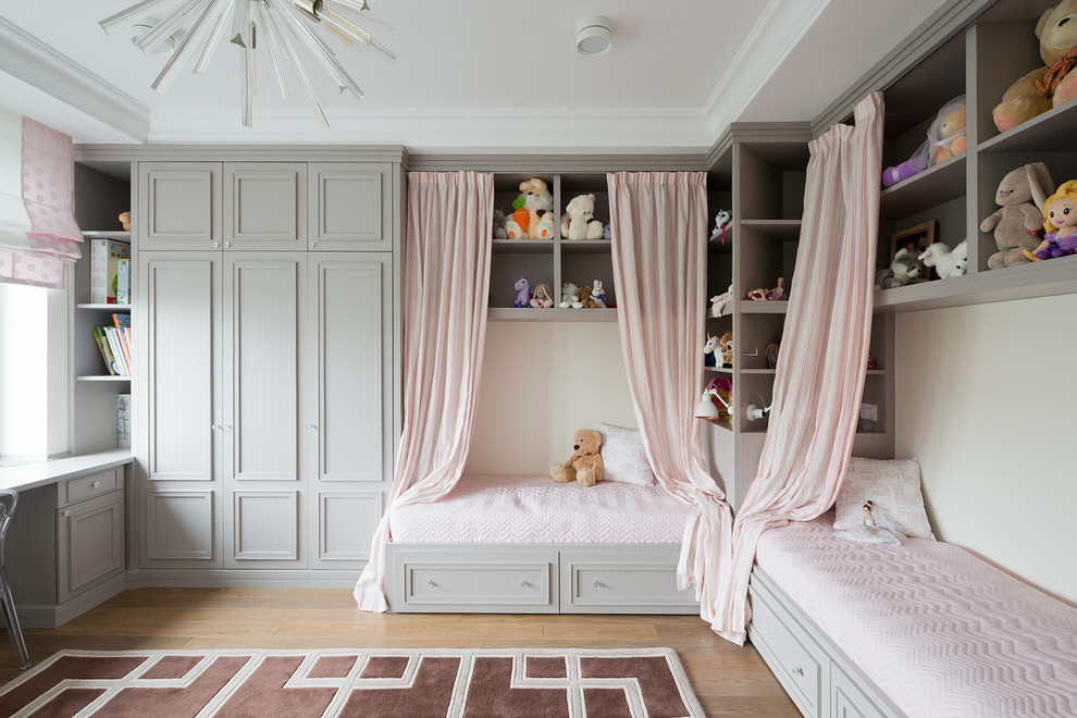 Inspiration for a large classic children’s room for girls in Moscow with white walls and light hardwood flooring.