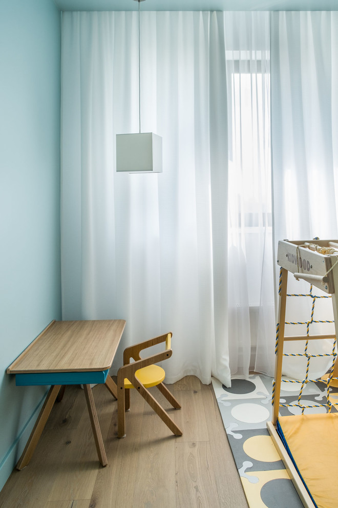 Foto di una cameretta per bambini contemporanea con pareti blu, pavimento in legno massello medio e pavimento marrone