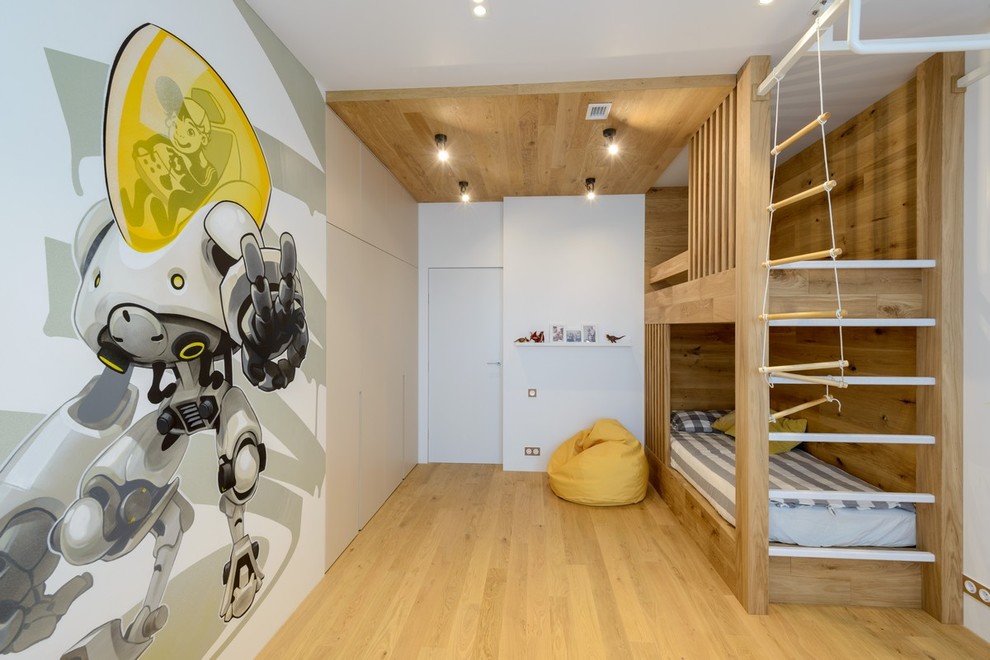 Ejemplo de dormitorio infantil de 4 a 10 años actual con paredes blancas y suelo de madera en tonos medios