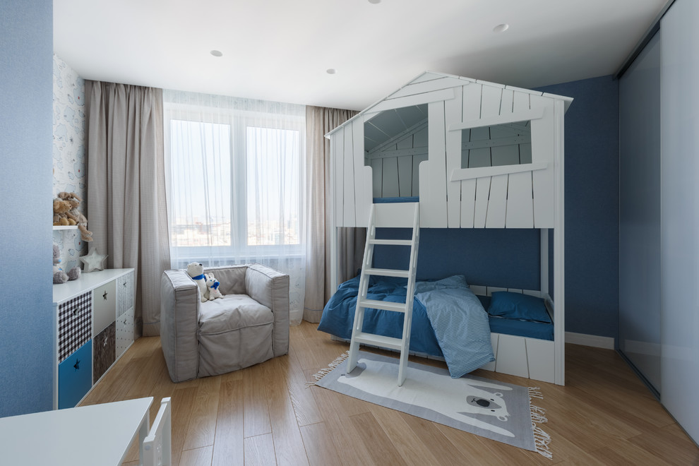 Inspiration för ett funkis barnrum kombinerat med sovrum och för 4-10-åringar, med blå väggar, ljust trägolv och beiget golv