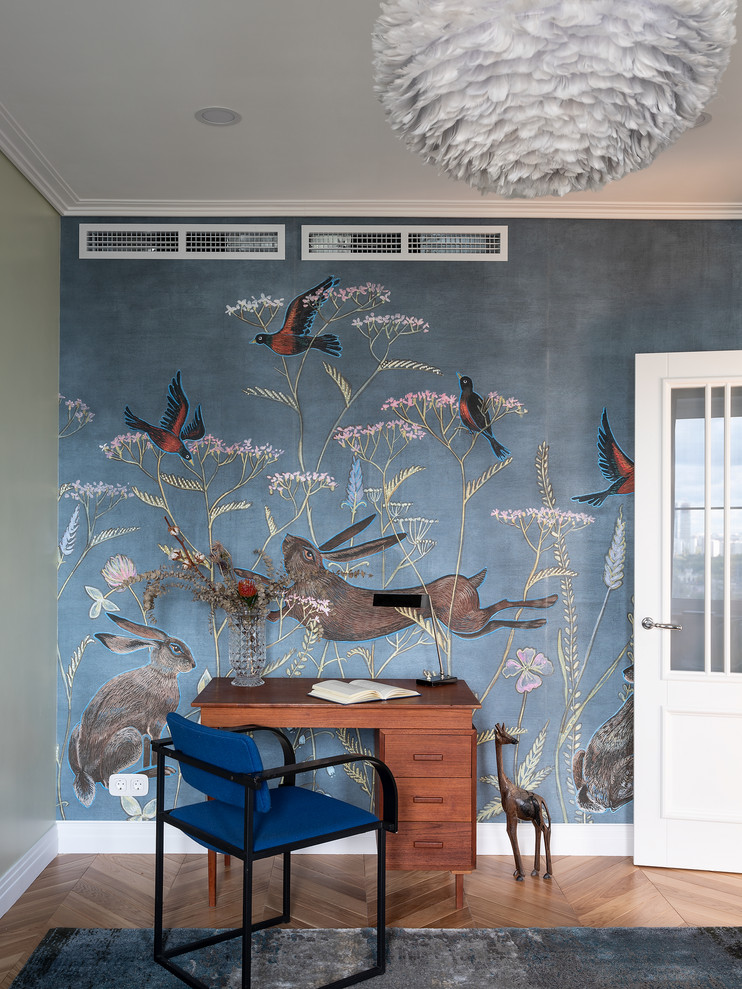 Inspiration pour une chambre neutre vintage avec un bureau, un mur bleu, un sol en bois brun, un sol marron et du papier peint.