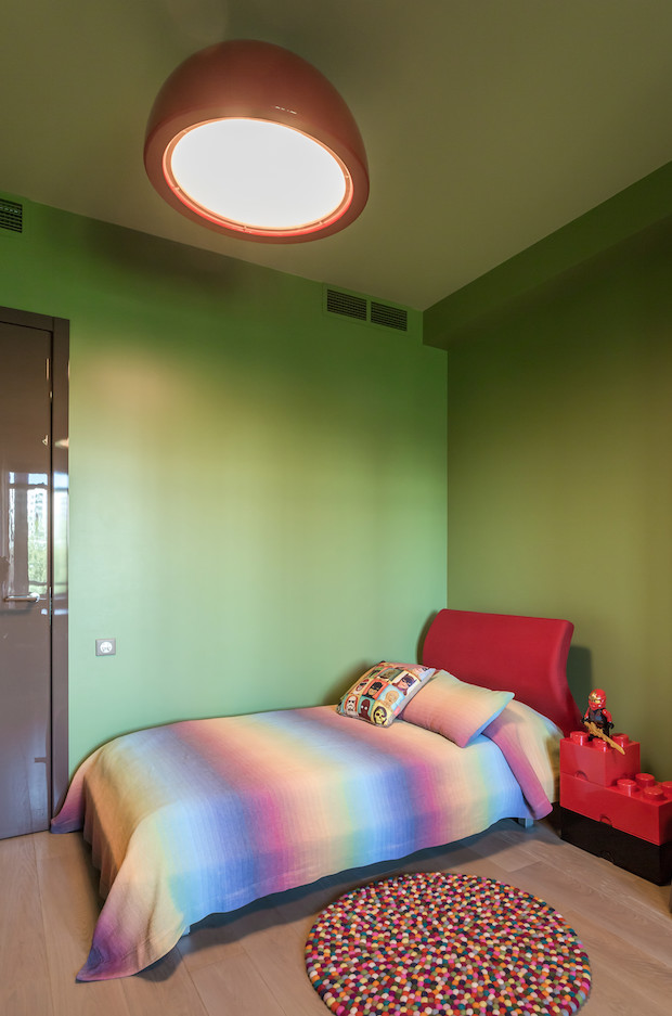 Foto på ett mellanstort funkis barnrum kombinerat med sovrum, med gröna väggar och ljust trägolv