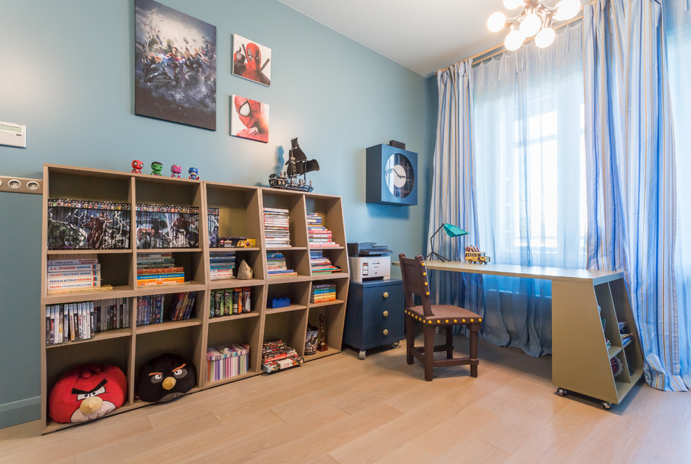 Aménagement d'une chambre d'enfant contemporaine de taille moyenne avec parquet clair, un bureau et un mur bleu.