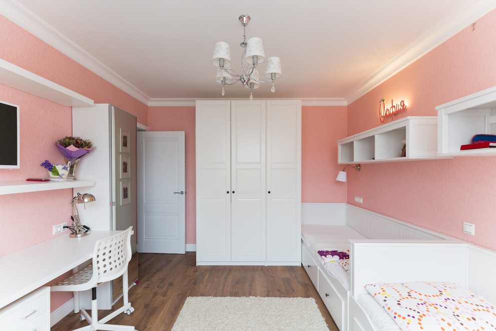 Nordisk inredning av ett flickrum kombinerat med skrivbord, med rosa väggar, mellanmörkt trägolv och brunt golv