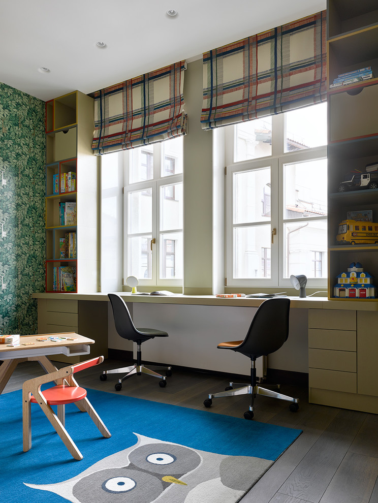 Modern inredning av ett könsneutralt barnrum kombinerat med skrivbord, med gröna väggar och mörkt trägolv