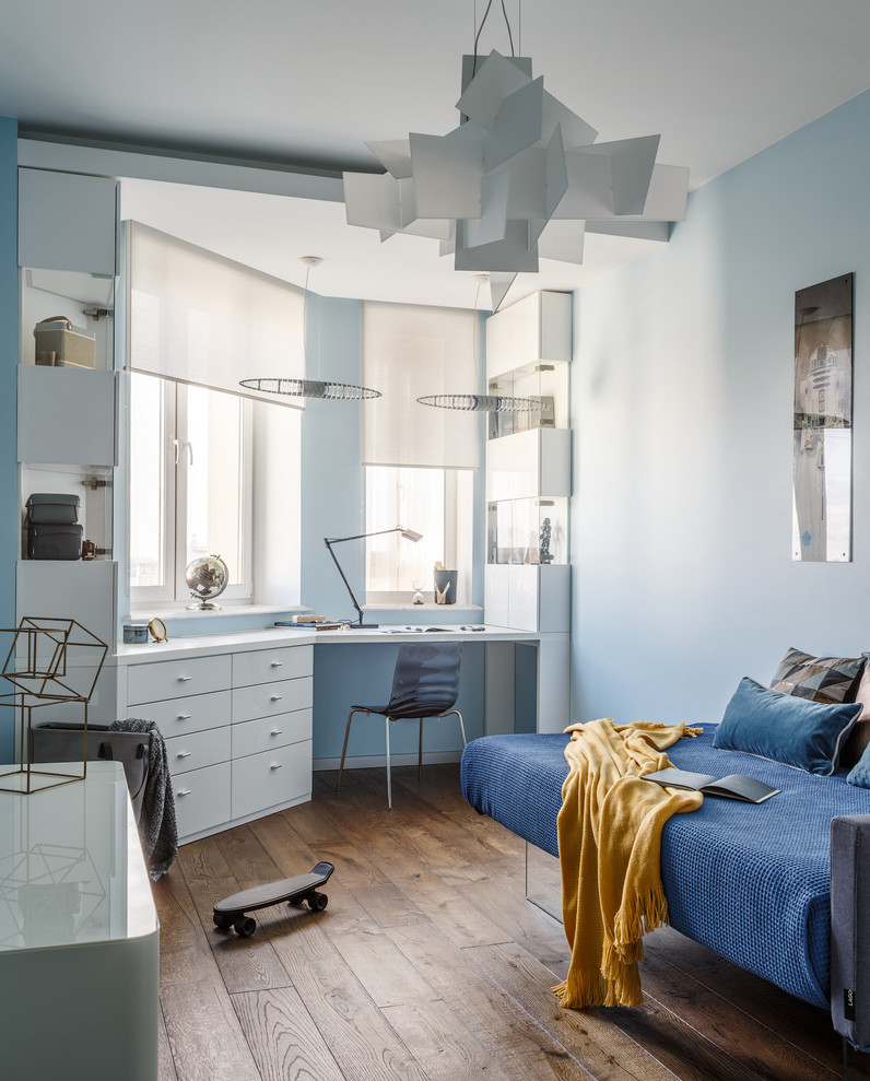 Diseño de dormitorio infantil contemporáneo con paredes azules, suelo de madera en tonos medios y suelo marrón