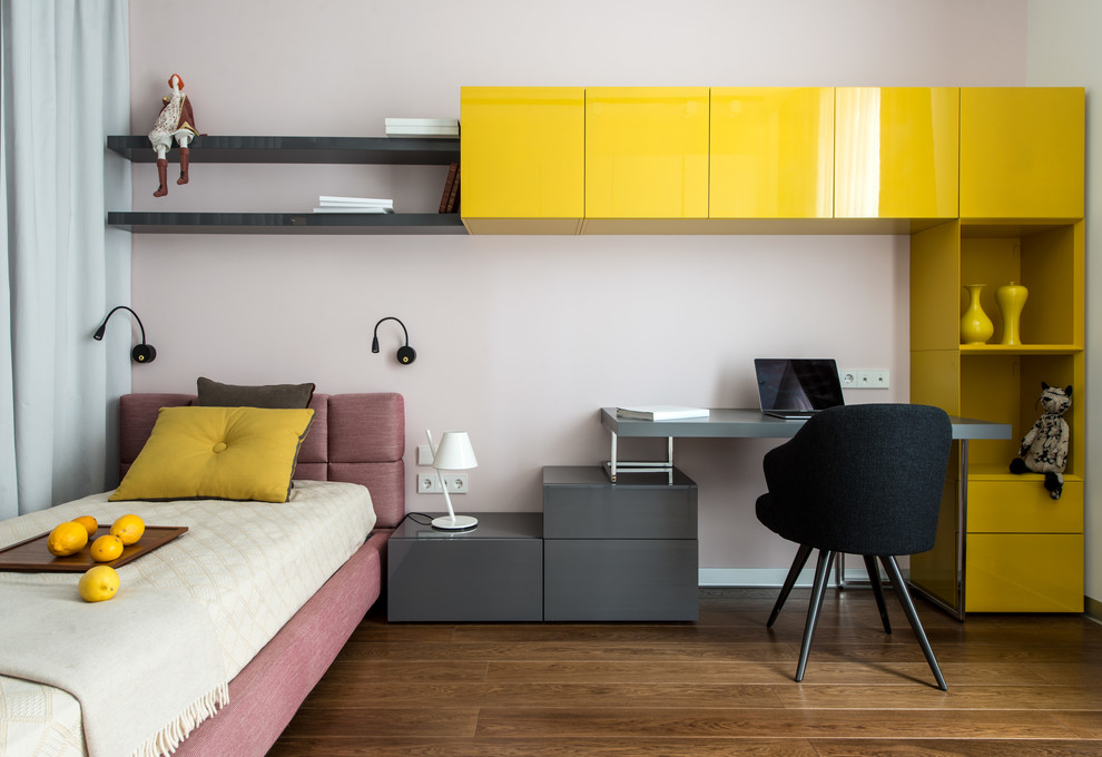 Diseño de habitación de niña contemporánea con escritorio, paredes rosas, suelo de madera en tonos medios y suelo marrón