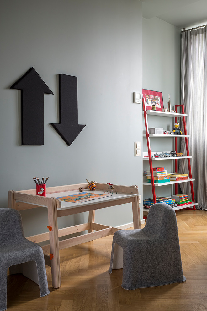 Exemple d'une chambre neutre de 1 à 3 ans chic avec un bureau, un sol en bois brun et un mur gris.