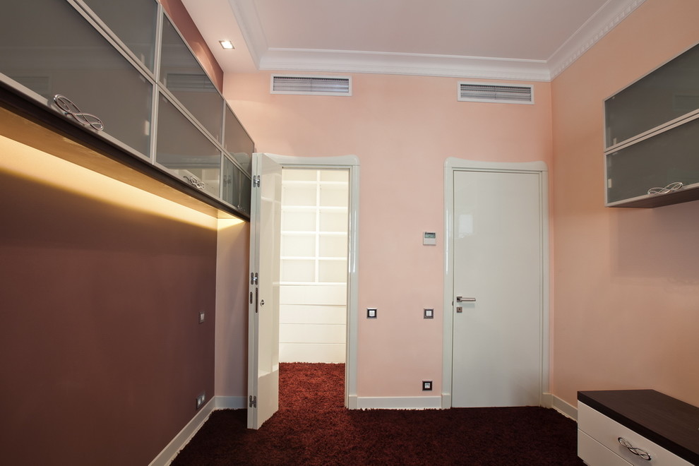 Esempio di una piccola cameretta per bambini design con pareti rosa, pavimento in legno verniciato e pavimento rosso