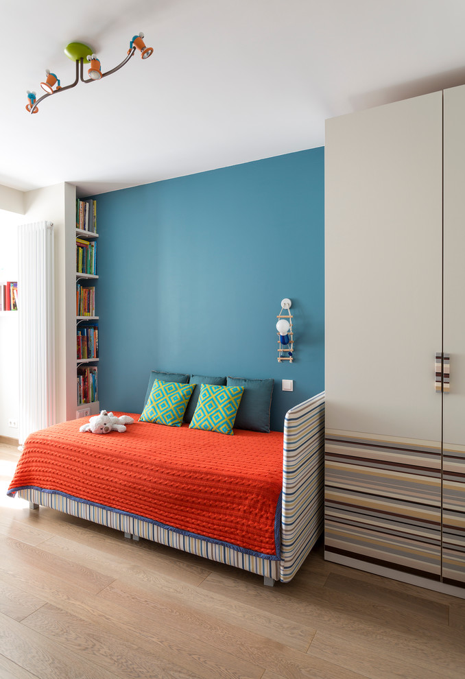Ejemplo de dormitorio infantil de 4 a 10 años actual de tamaño medio con suelo de madera clara y paredes azules