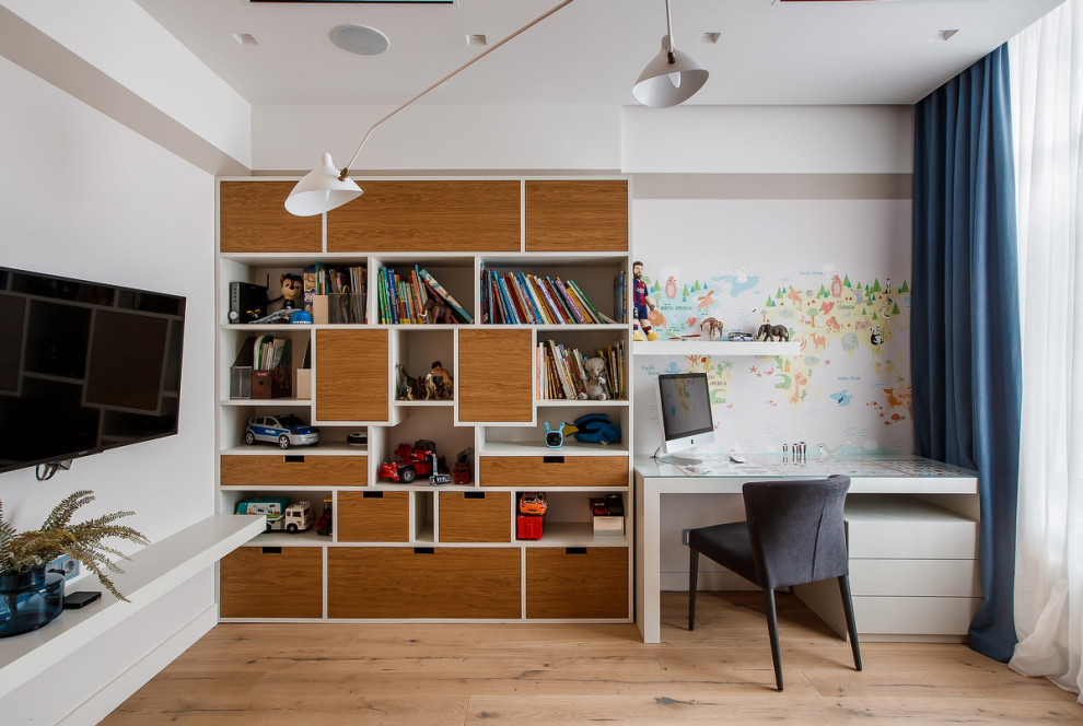 Cette photo montre une chambre de garçon de 4 à 10 ans tendance de taille moyenne avec un bureau, un mur blanc, parquet clair et un sol beige.